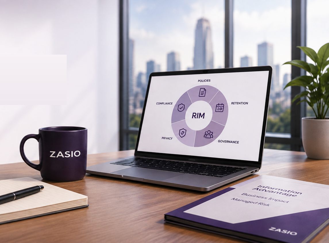 A desk with a Zasio mug, a notebook, and a laptop showing a RIM program wheel — policies, retention, governance, privacy, and compliance around a RIM hub — beside a Zasio Information Advantage brochure, with a city skyline through the window