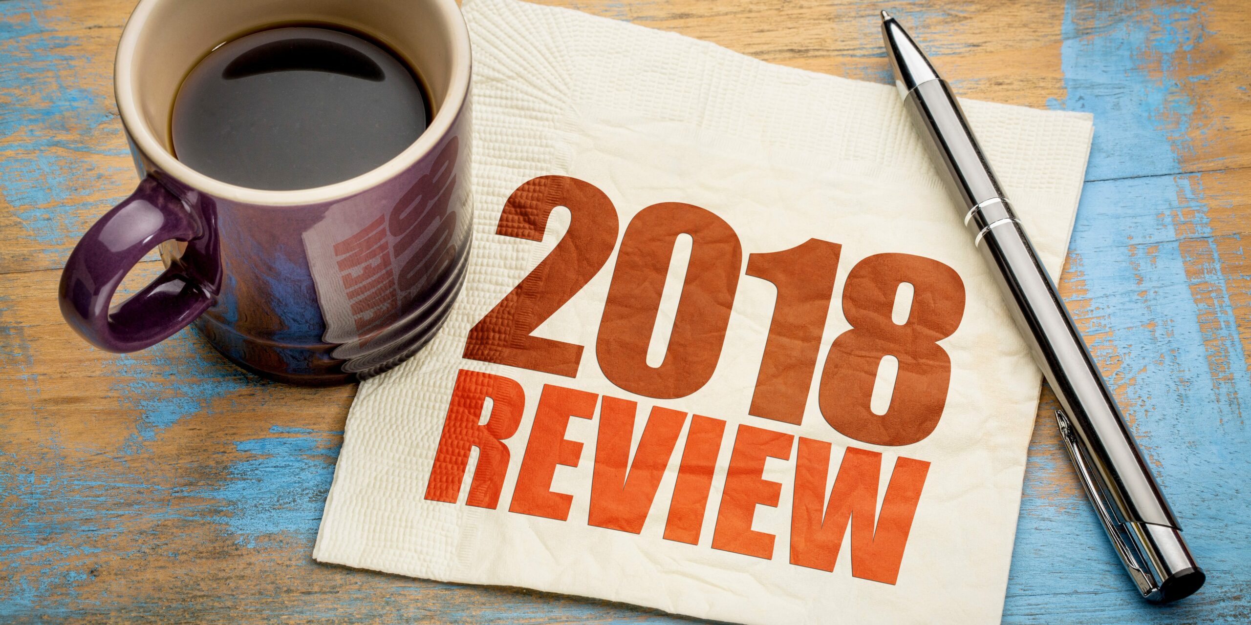 2018 review napkin on desk with pen and mug