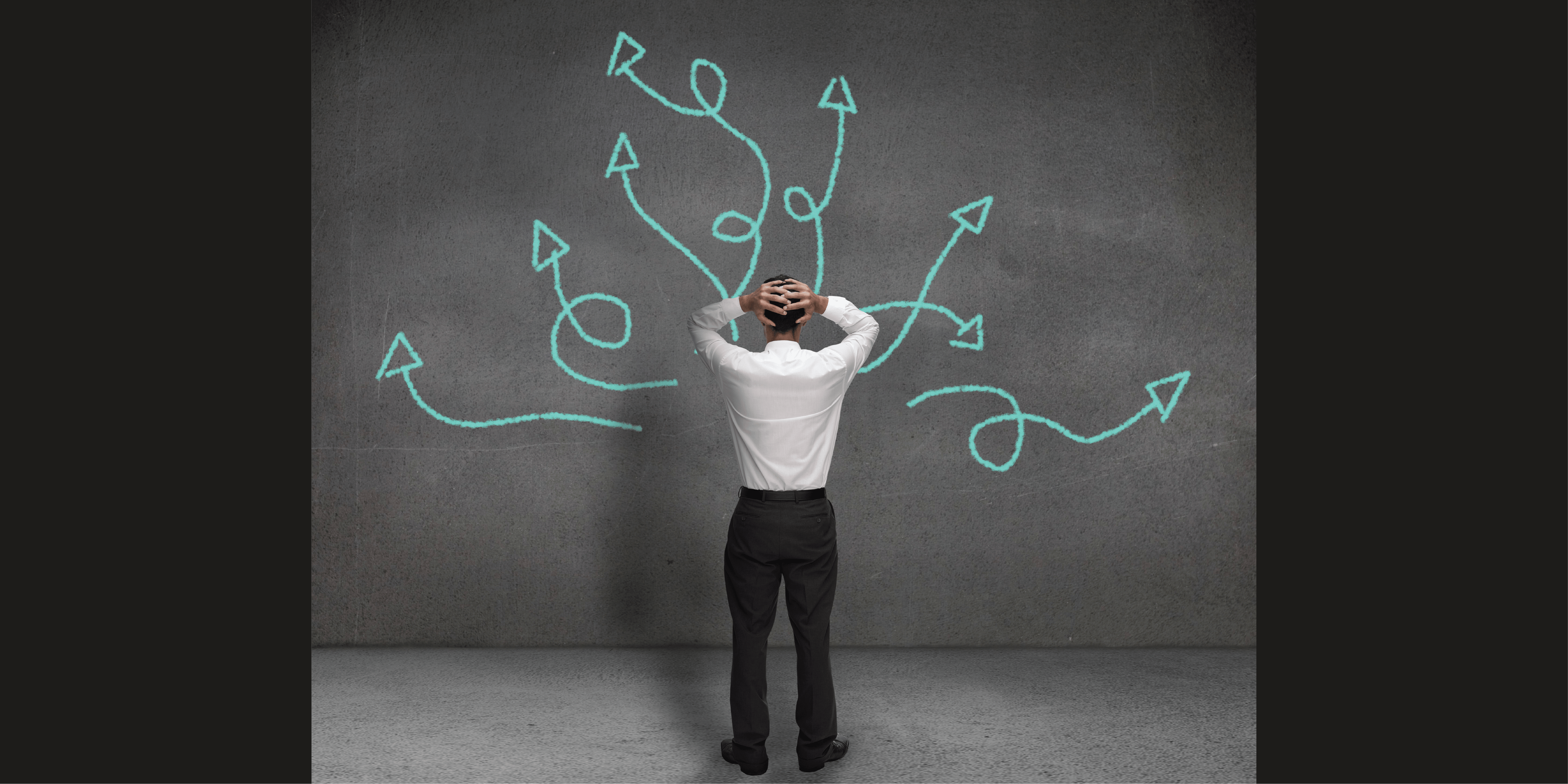 businessman confused with arrows representing thoughts in every direction