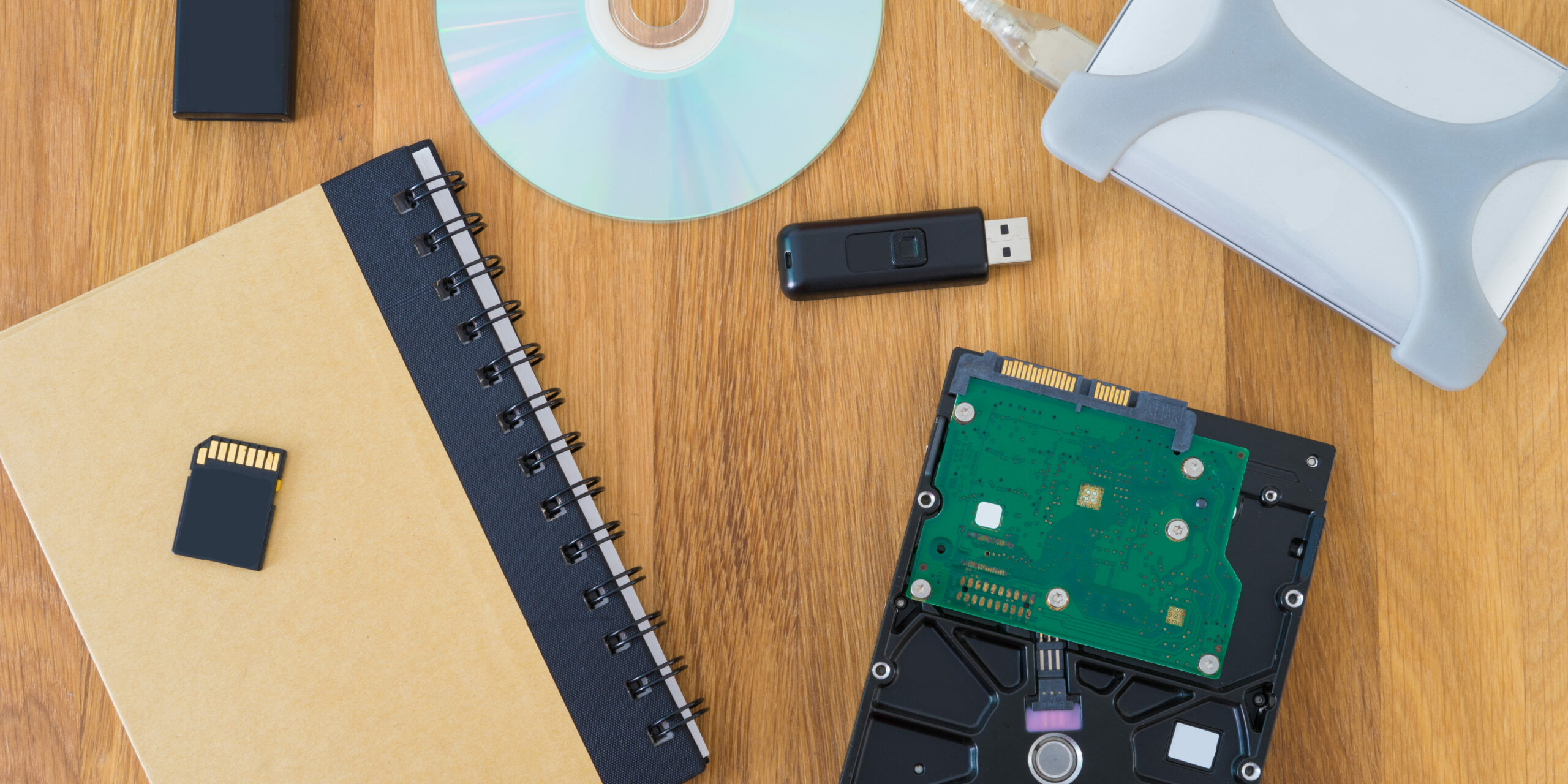 top view of desk with computer parts and notebook