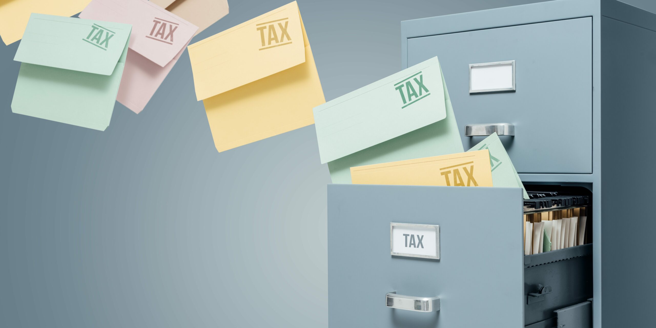 Closeup of filing cabinet with tax documents flying out