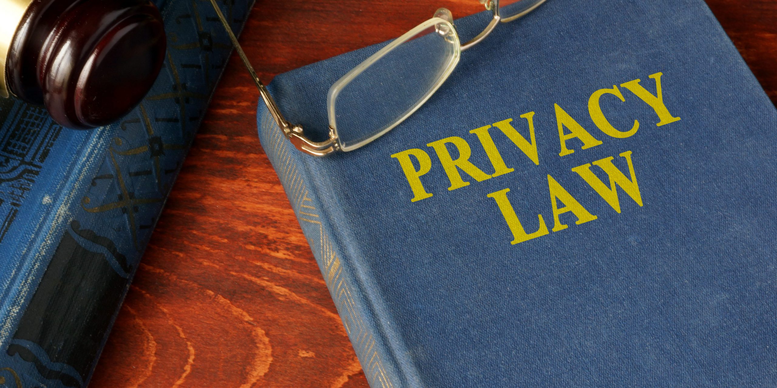 Privacy law book on desk with glasses and gavel