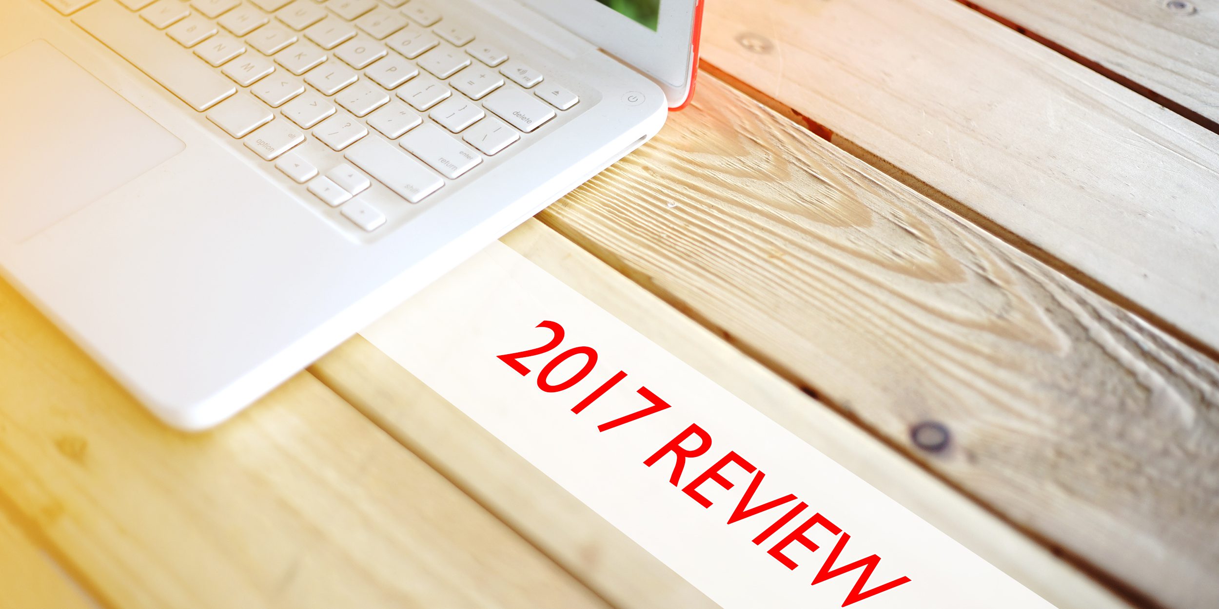 laptop on wood table next to 2017 review lettering